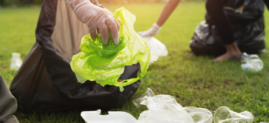 keeping garbage plastic bottle into black bag at park